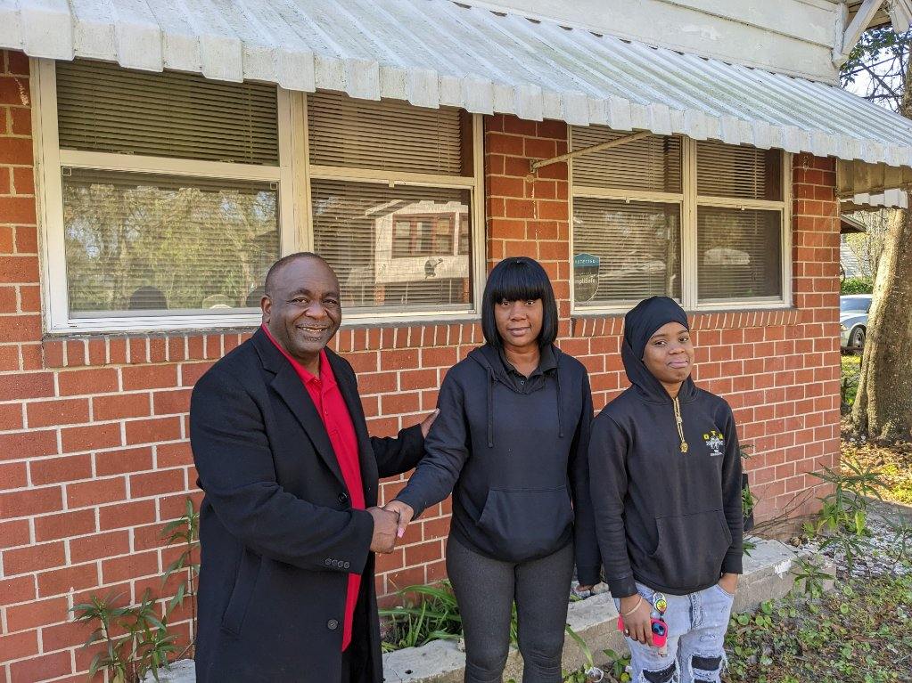 Paul Tutwiler, executive director of Northwest Jacksonville Community Development Corporation (NWJCDC), welcomes new tenants to a home secured with a Community Foundation loan
