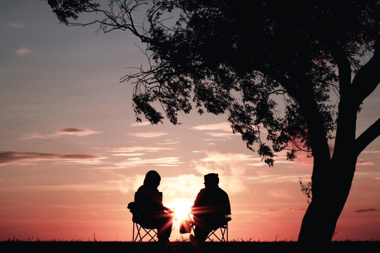 Couple sitting in front of sunset